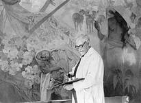 Mucha posant devant la fresque